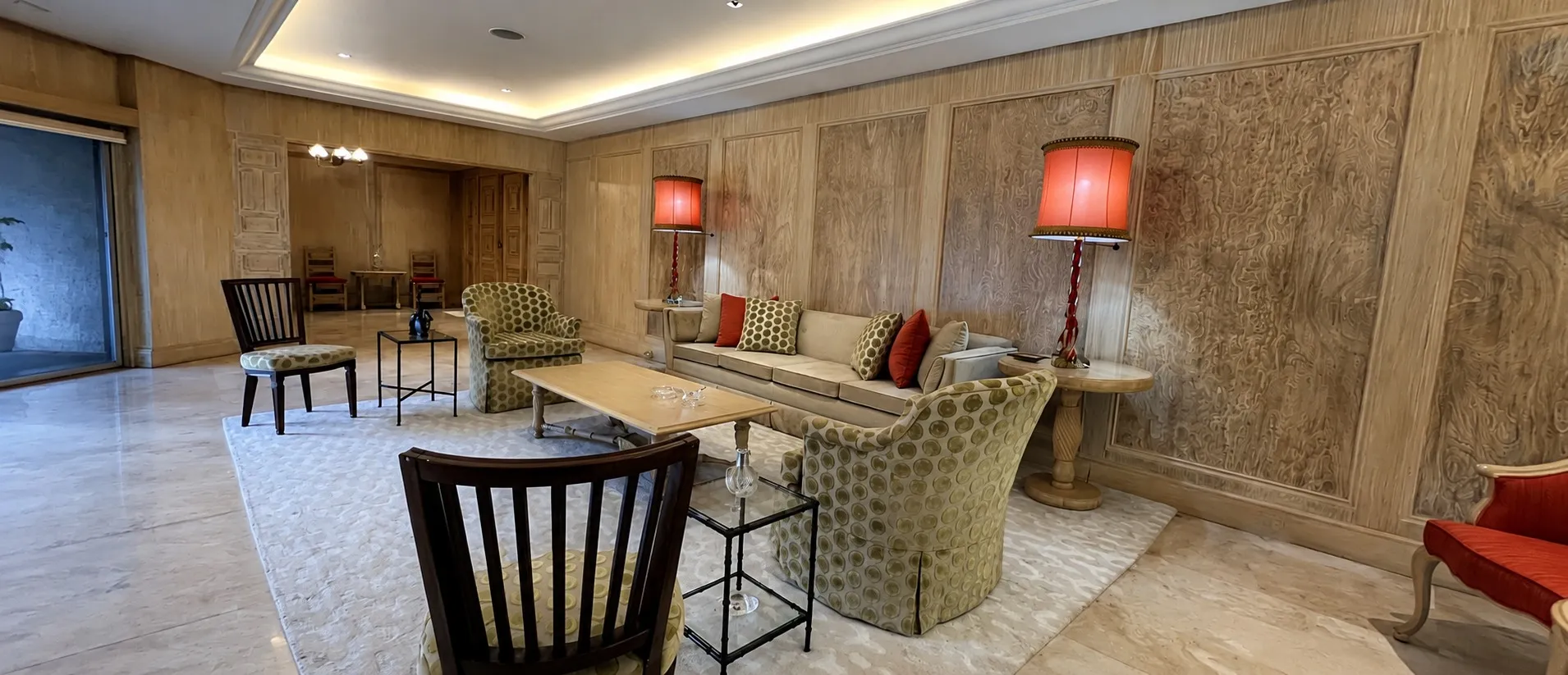 Wood-paneled lounge interior with patterned seating and red lamps