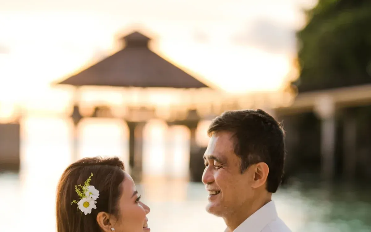 Couple embracing outdoors in warm golden light at sunset